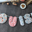 Load image into Gallery viewer, Banderole lettres en tissus matelassées personnalisable, prénom enfant, mot, décoration intérieure, décoration chambre enfant, évènement, anniversaire, guirlande de mot, banderole prénom artisanale, idée cadeau originale, puff letter, les Fantaisies de Malou
